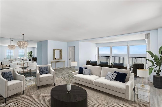 living room featuring hardwood / wood-style floors, a water view, and an inviting chandelier