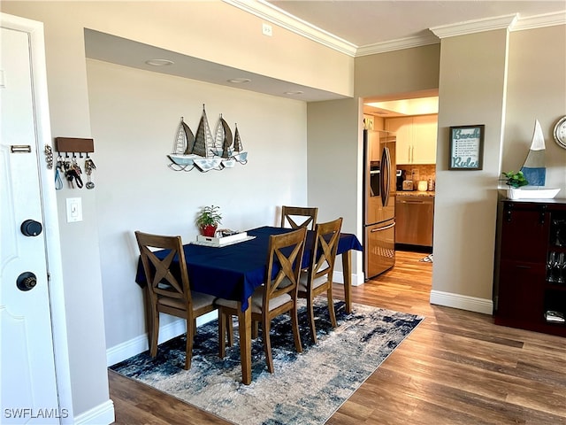 dining area featuring light wood-type flooring and ornamental molding