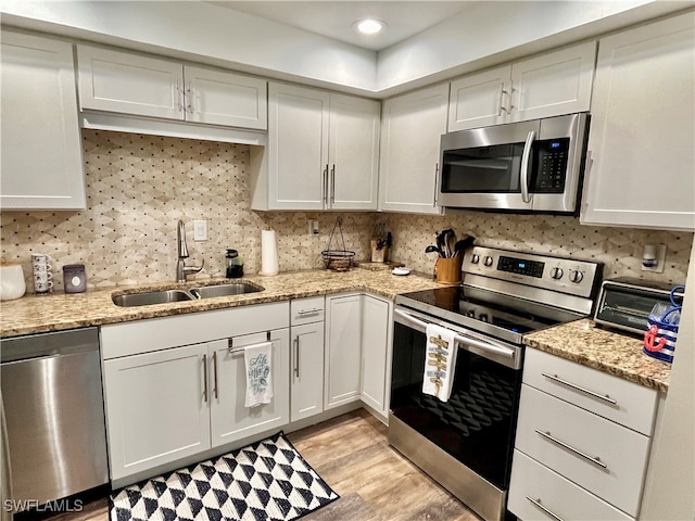 kitchen featuring white cabinets, stainless steel appliances, light hardwood / wood-style flooring, and sink