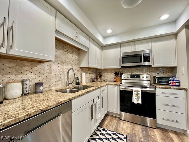 kitchen featuring white cabinets, stainless steel appliances, light hardwood / wood-style floors, and sink