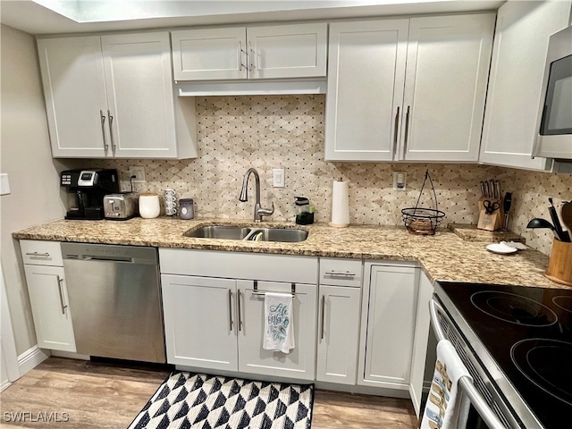 kitchen featuring sink, white cabinets, stainless steel appliances, and light hardwood / wood-style floors