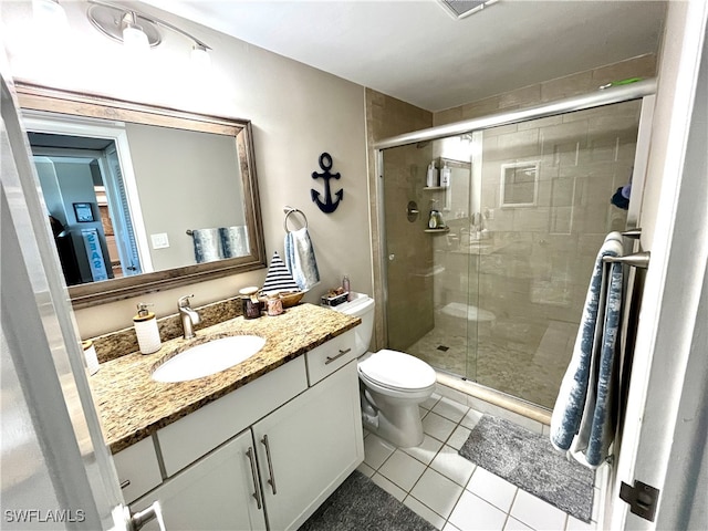 bathroom with toilet, vanity, tile patterned floors, and a shower with door