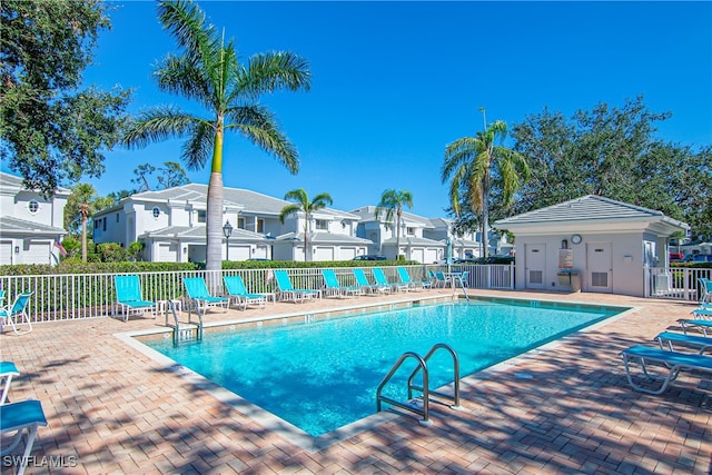 view of pool with an outbuilding and a patio