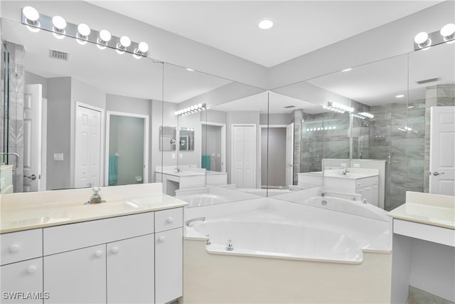 bathroom featuring vanity and independent shower and bath