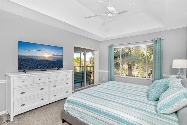 bedroom with carpet flooring, ceiling fan, a raised ceiling, and access to outside