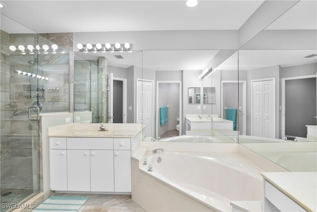 full bathroom with vanity, separate shower and tub, and toilet