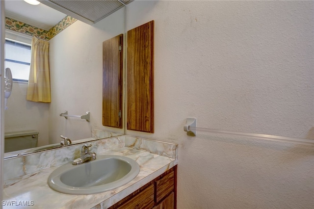 bathroom featuring vanity and toilet