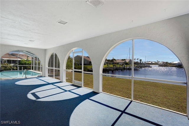 unfurnished sunroom with a water view and a pool