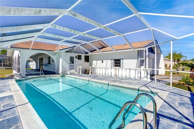 view of pool with glass enclosure and a patio