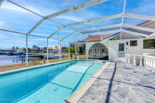 view of pool with a lanai, a water view, and a patio