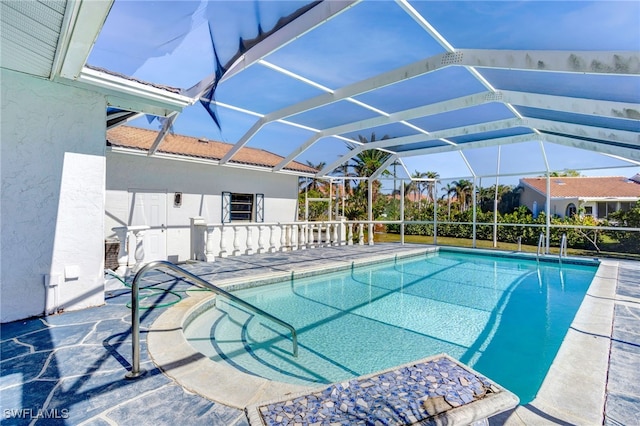 view of swimming pool with glass enclosure and a patio area