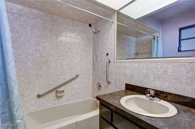 bathroom with decorative backsplash, shower / bath combination with curtain, vanity, and tile walls