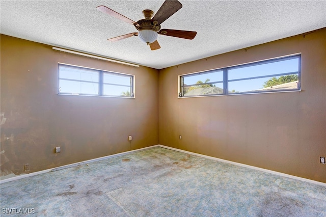 empty room featuring carpet flooring, ceiling fan, and a textured ceiling