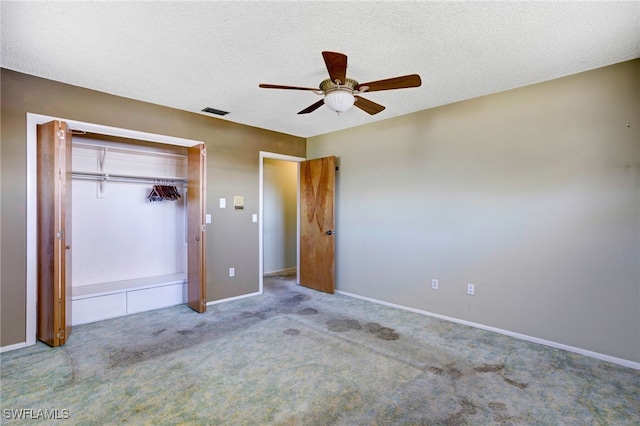 unfurnished bedroom with ceiling fan, a textured ceiling, light carpet, and a closet