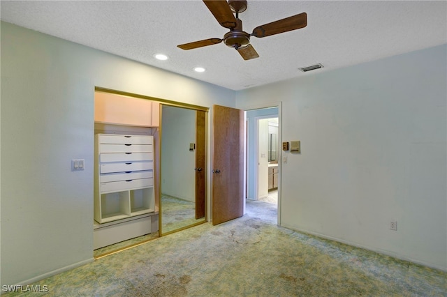 unfurnished bedroom featuring light carpet, a textured ceiling, a closet, and ceiling fan