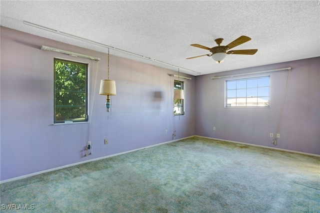 carpeted spare room featuring a textured ceiling and ceiling fan