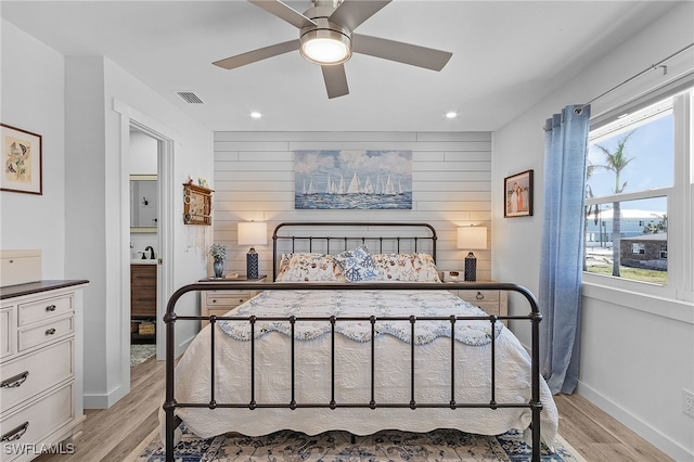 bedroom featuring light hardwood / wood-style floors, multiple windows, and ceiling fan