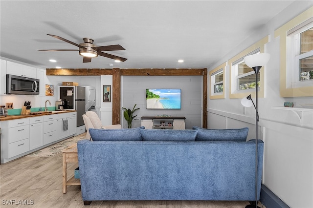 living room featuring ceiling fan, light hardwood / wood-style flooring, and sink