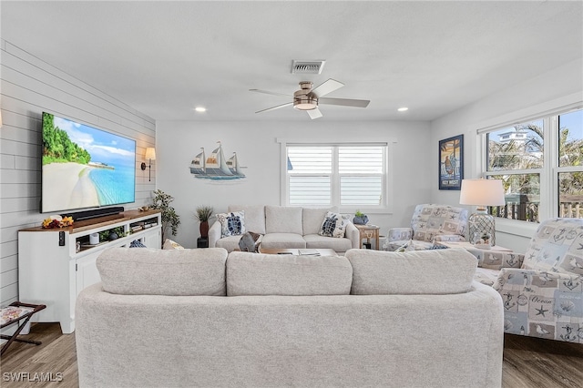 living room featuring wood-type flooring, plenty of natural light, and ceiling fan