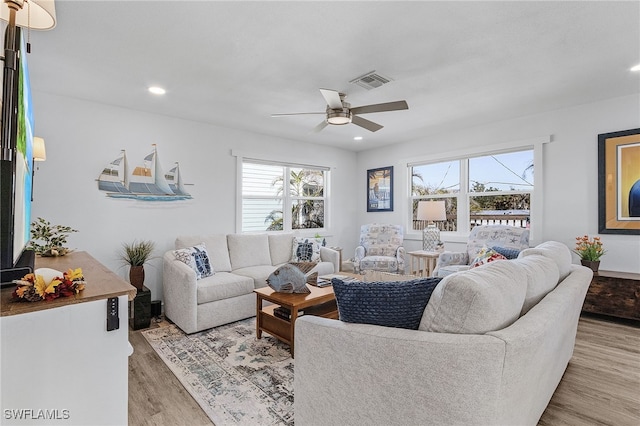 living room with ceiling fan and light hardwood / wood-style flooring