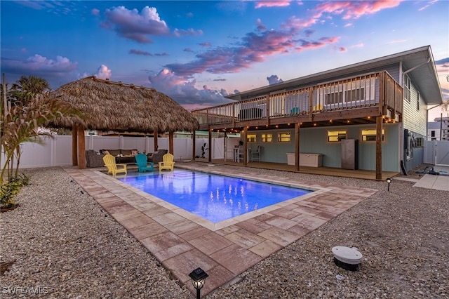 pool at dusk featuring a patio area and a deck