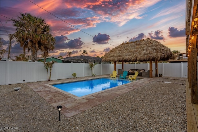 pool at dusk featuring a patio