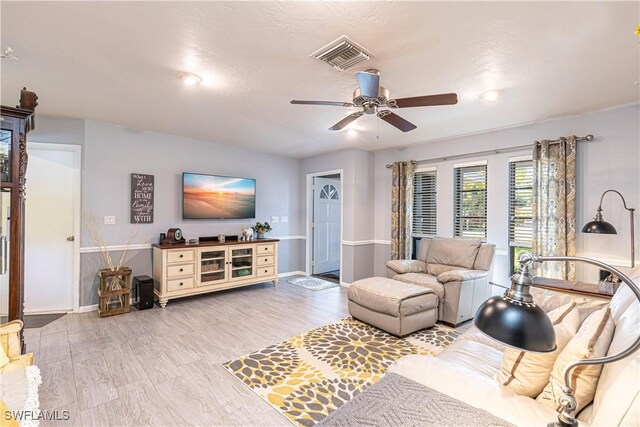 living room with light hardwood / wood-style floors and ceiling fan