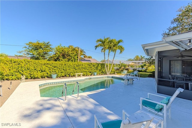 view of pool with a sunroom and a patio area