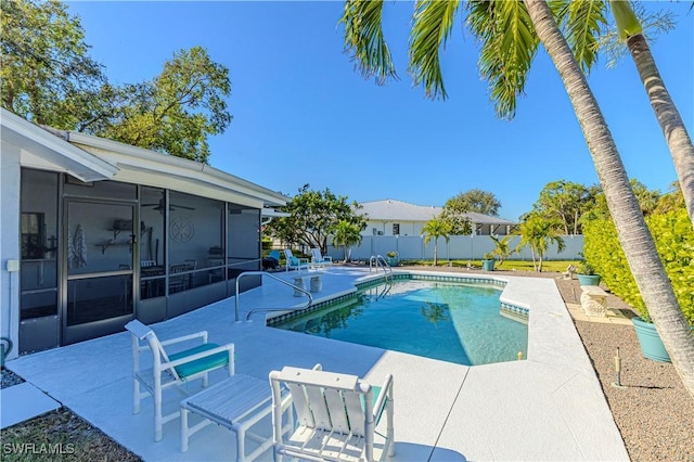 view of pool with a sunroom and a patio