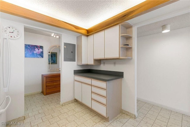 kitchen featuring white cabinetry, electric panel, and a textured ceiling