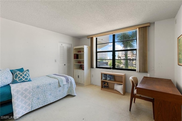 bedroom with a textured ceiling, a closet, and carpet flooring