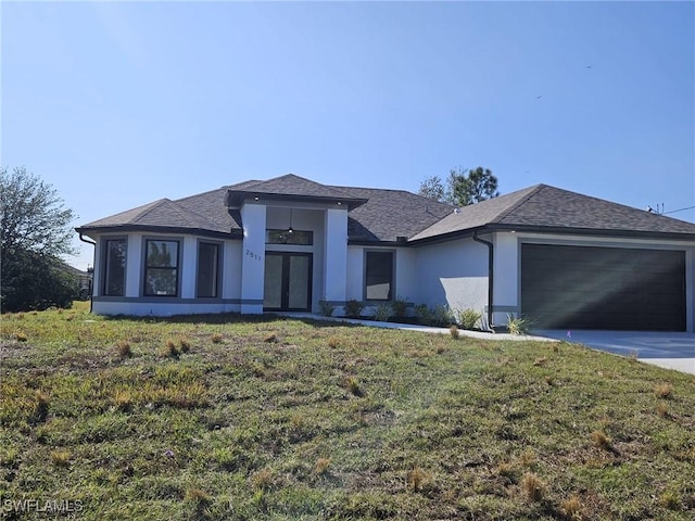 view of front of home with french doors, a garage, and a front lawn