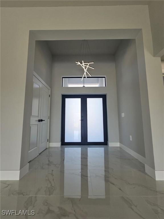 entryway featuring a notable chandelier and french doors