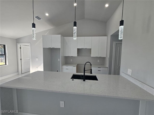 kitchen with white cabinets, hanging light fixtures, lofted ceiling, and sink