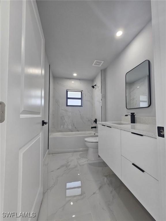 full bathroom featuring vanity, toilet, and tiled shower / bath