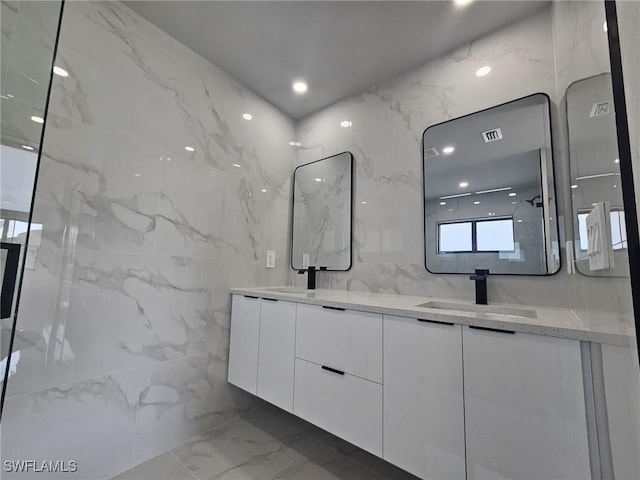 bathroom with vanity and tile walls