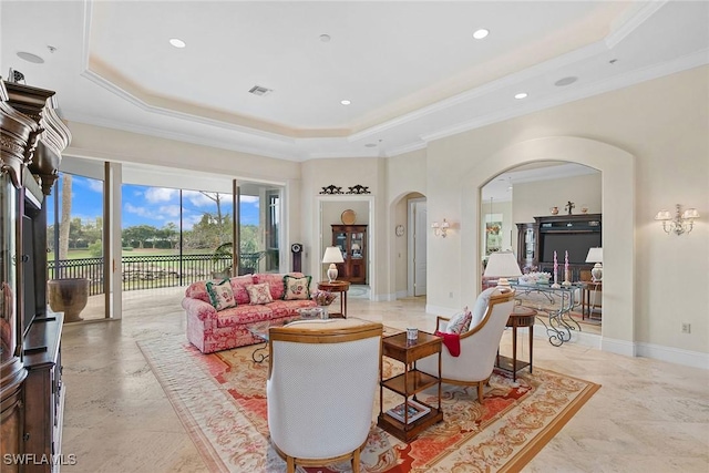 living room with a tray ceiling and crown molding