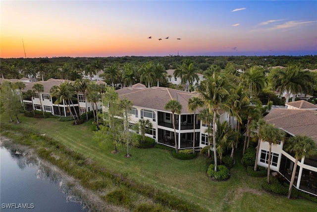 aerial view at dusk featuring a water view