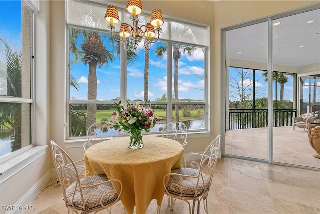 sunroom / solarium featuring a water view and a notable chandelier