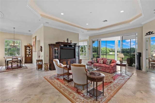 living room with a raised ceiling, ornamental molding, and a chandelier