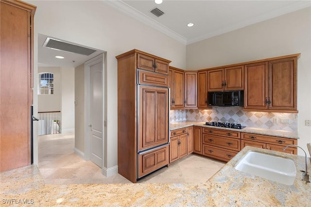 kitchen featuring visible vents, black appliances, decorative backsplash, and a sink