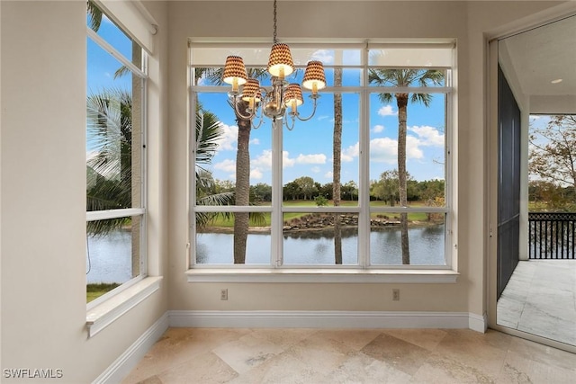 unfurnished sunroom with a notable chandelier and a water view