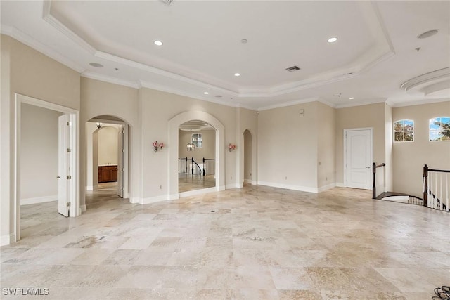 interior space featuring arched walkways, visible vents, crown molding, and a tray ceiling