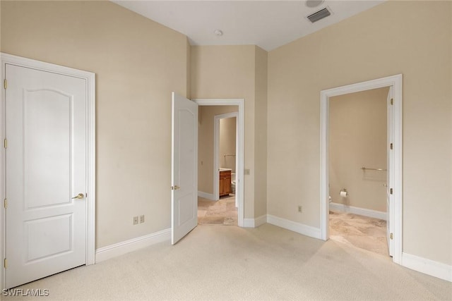 unfurnished bedroom featuring visible vents, baseboards, ensuite bathroom, and carpet