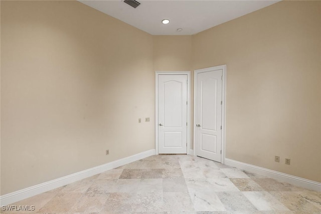 unfurnished room featuring visible vents and baseboards