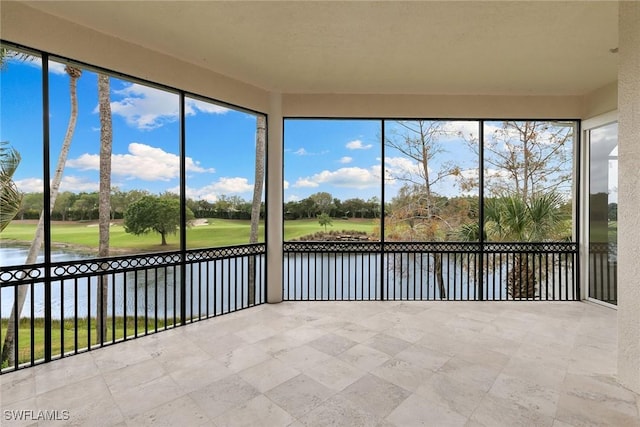 unfurnished sunroom featuring plenty of natural light and a water view