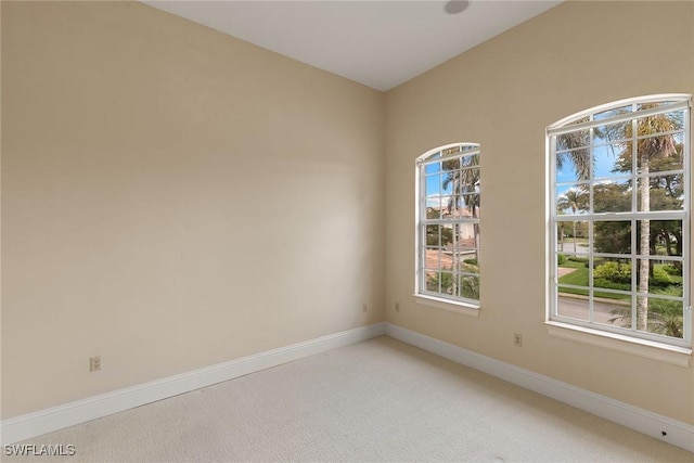 empty room with baseboards and light carpet