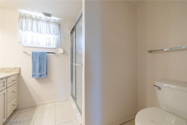 bathroom featuring vanity, toilet, a shower with door, and tile patterned flooring