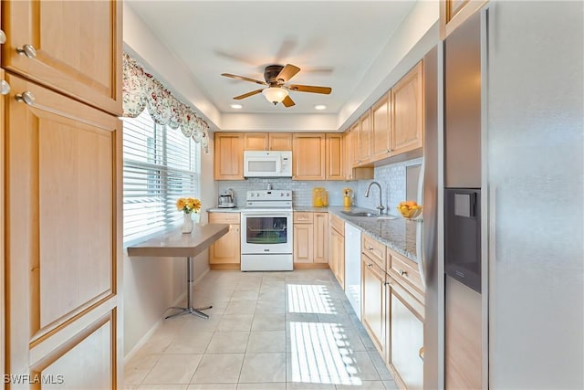 kitchen featuring light brown cabinetry, sink, decorative backsplash, light tile patterned floors, and white appliances