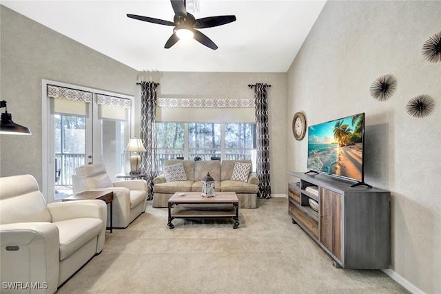 carpeted living room featuring a towering ceiling, french doors, and ceiling fan